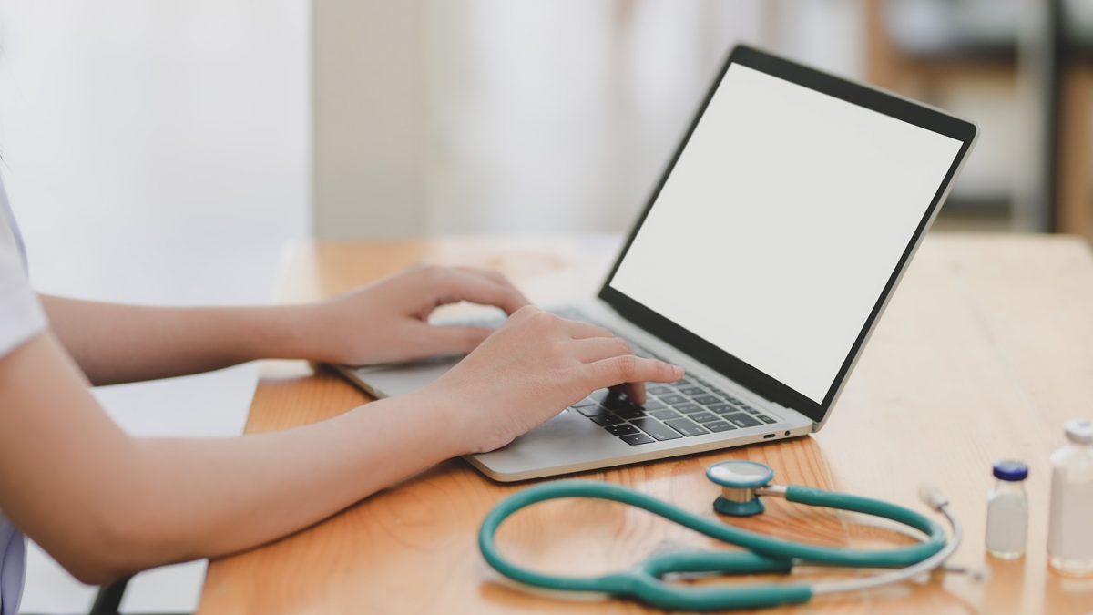 Nurse at computer typing for Telehealth